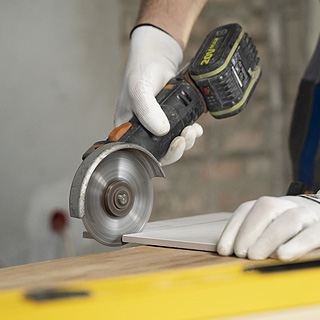 Lavoratore taglia una lastra di cartongesso chea ndrà applicata ad una parete.