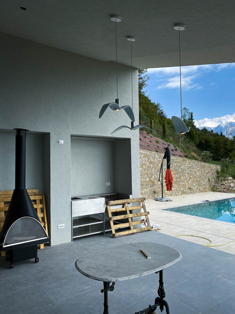 Pareti esterne rivestite con pannelli in fibrocemento presso villa privata a Tignale, garantendo resistenza e durabilità.