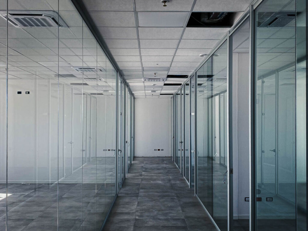 Ambiente ufficio rifinito con cartongesso e soffitto modulare per una divisione intelligente degli spazi, combinando stile e praticità.